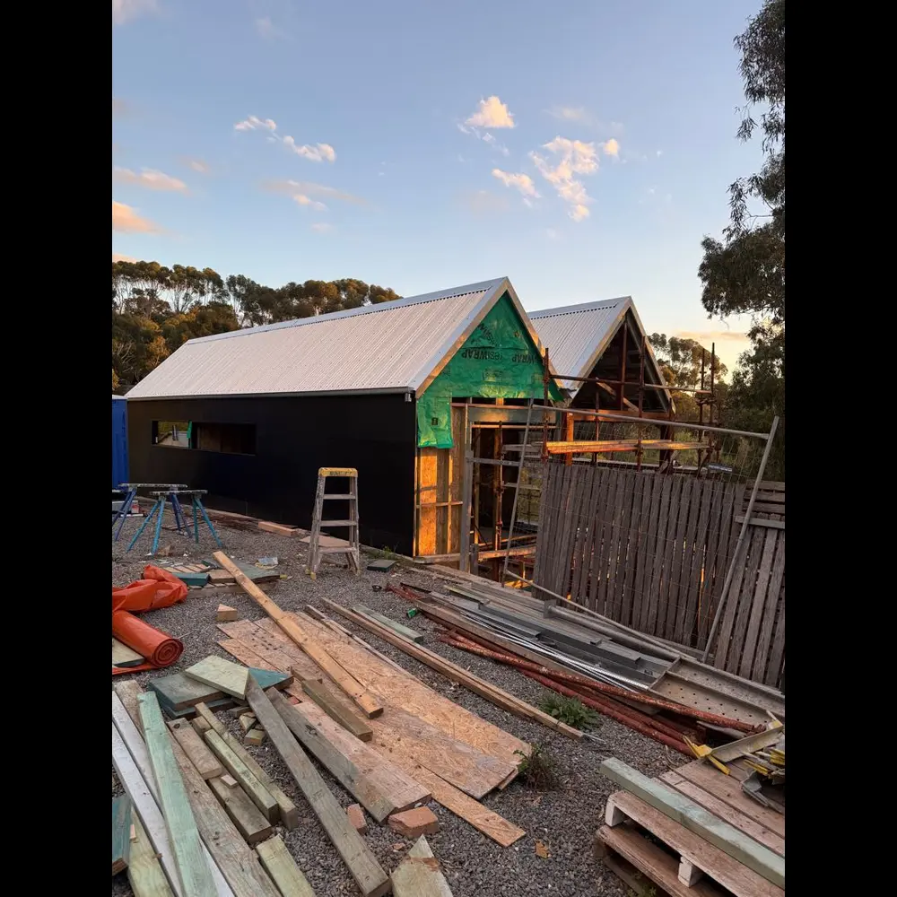 New home with cladding and roof on, photographed at dusk