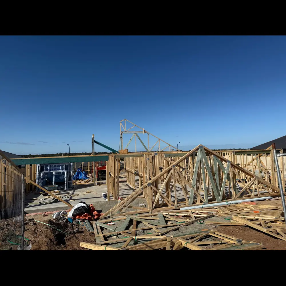 Roof truss framing on a new home under a clear blue sky